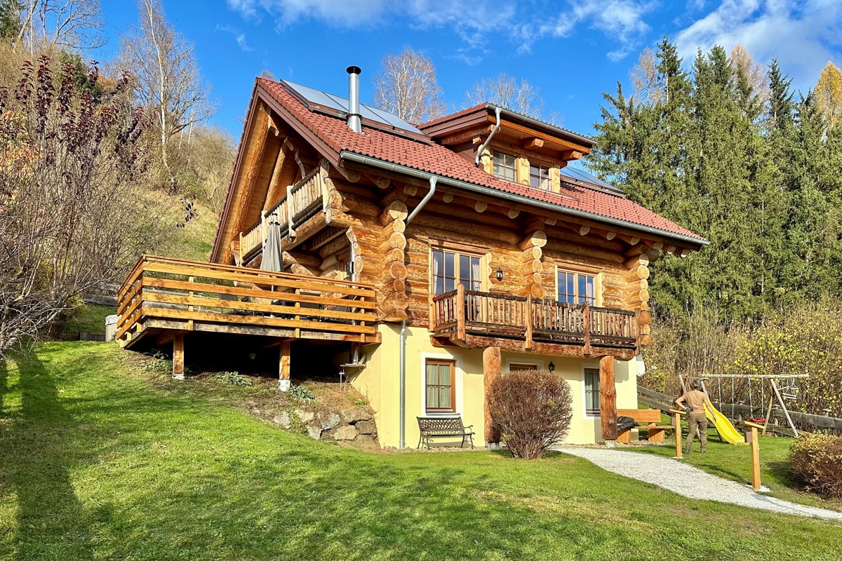 Die Kreischberg Lodge von der Gartenseite mit Terrasse und Spielgerät
